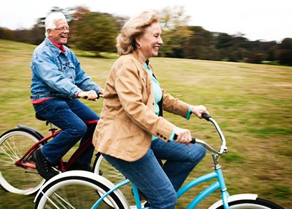 Retired couple riding bicycles on a hill