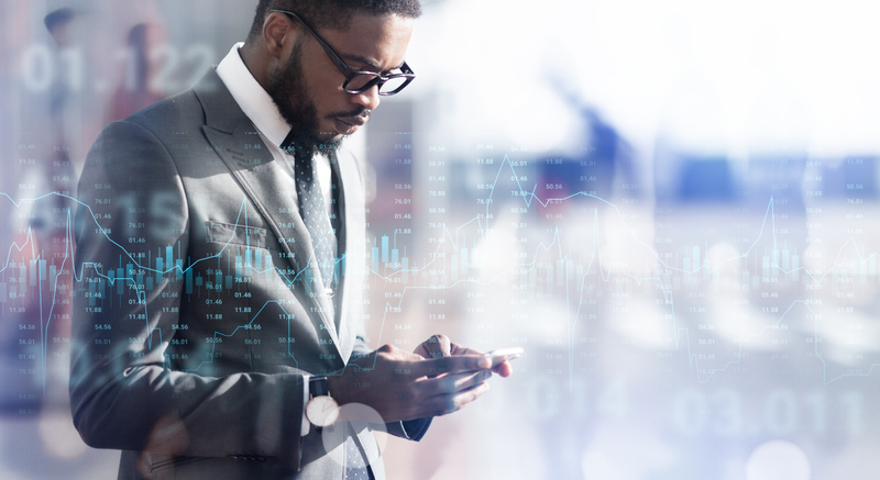 Man checks his smartphone for information on the U.S. dollar performance.